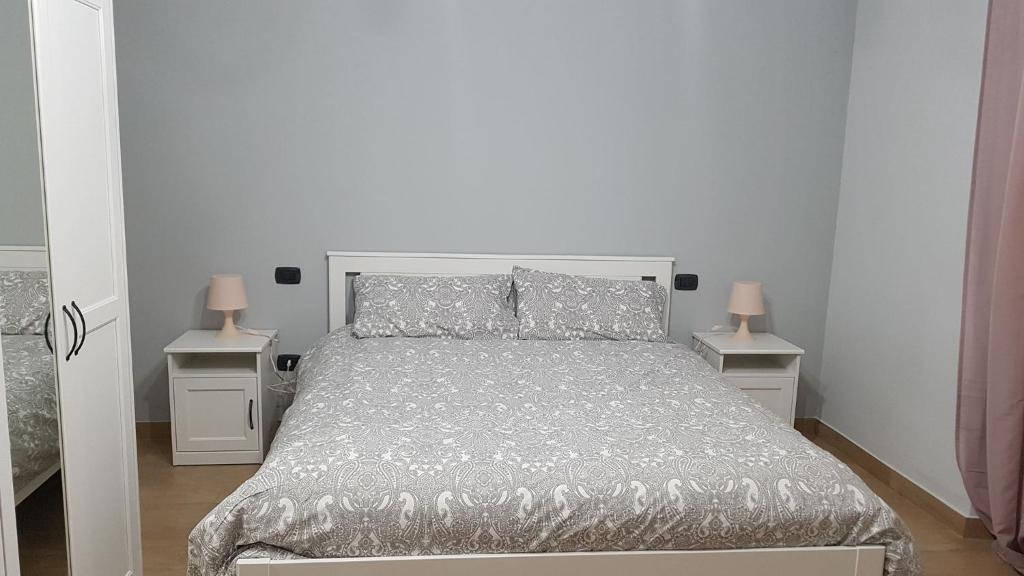 een slaapkamer met een groot bed met 2 nachtkastjes bij Certe notti in Taranto