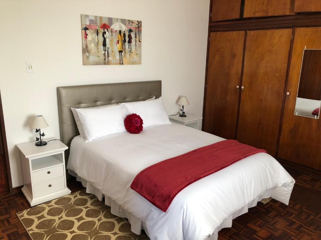 フンシャルにあるCity View Gardens IIのベッドルーム1室(赤い花のベッド1台付)