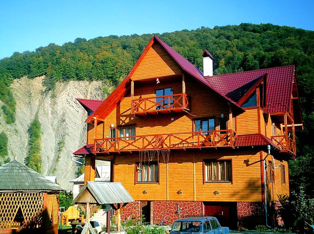 ein großes Holzhaus mit Balkon in der Unterkunft У Тараса і Лесі in Jaremtsche