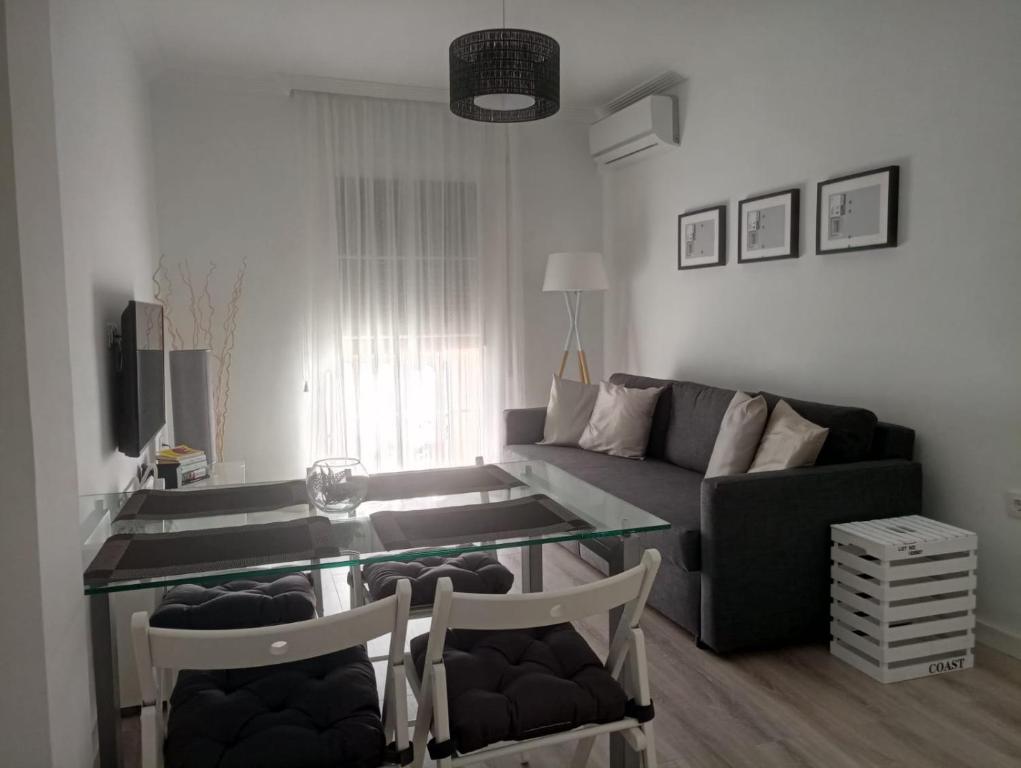 ein Wohnzimmer mit einem Sofa und einem Glastisch in der Unterkunft Apartamento Vega in Baena