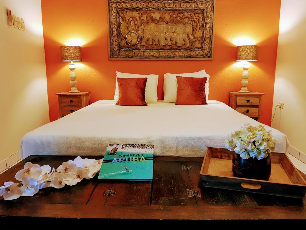 een slaapkamer met een bed en een boek op een tafel bij Brisas Studio Apartments in Palm-Eagle Beach