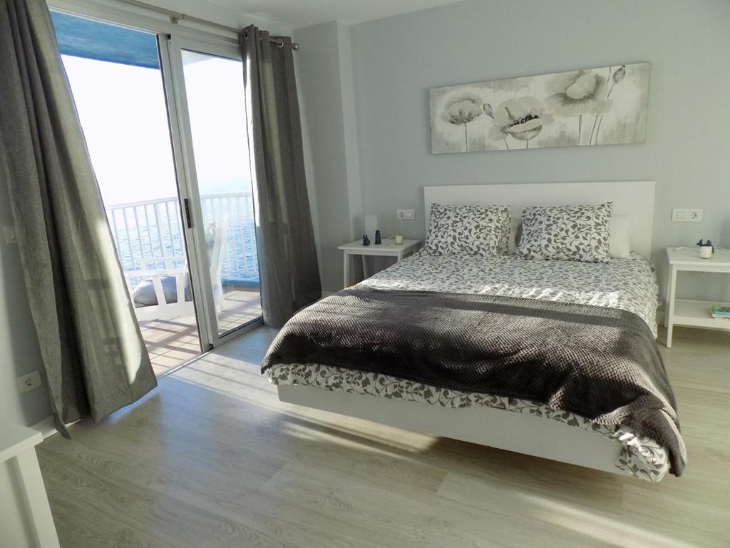 a bedroom with a bed and a large window at Crepúsculo in Puerto de la Madera