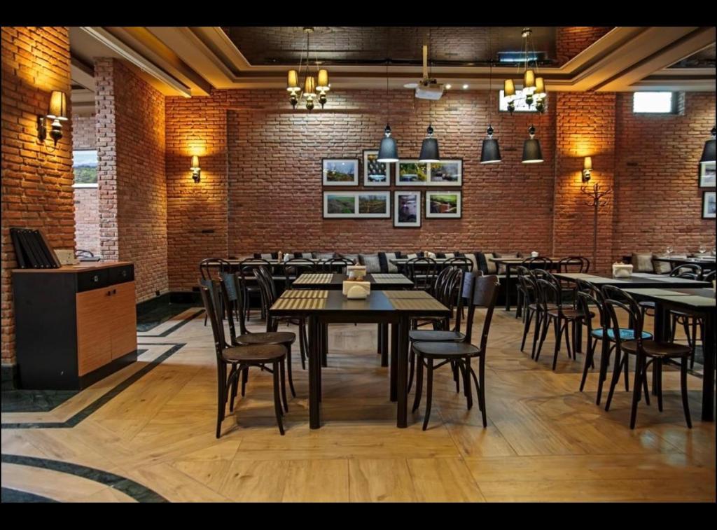a restaurant with tables and chairs and a brick wall at Orbi Palace, room 536 in Bakuriani
