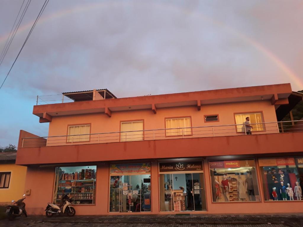 un edificio con un arco iris en el fondo en Apartamentos Bombinhas, en Bombinhas