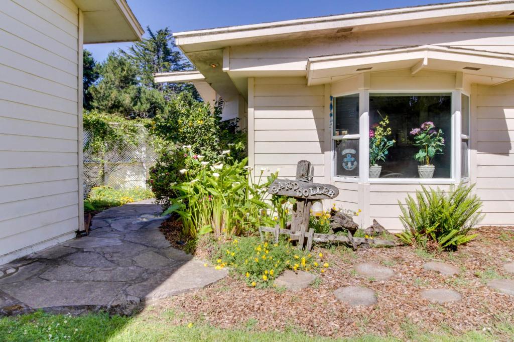 a house with a bench in the front yard at Mendocino Dunes - Sand Dollar in Fort Bragg