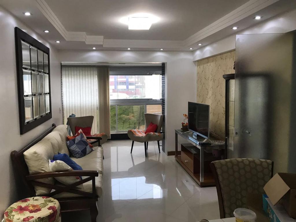 uma sala de estar com um sofá e uma televisão em SALVADOR SUITES RESIDENCE em Salvador