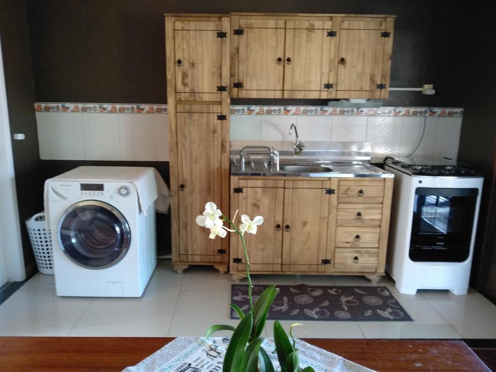 cocina con lavadora y fregadero en Casa a 50 mt da Praia., en Bombinhas