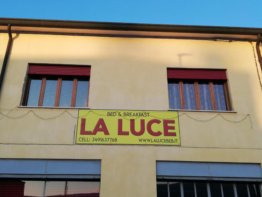 a building with a lauce sign in front of two windows at B&B La Luce - Casa di Ale in Loreo