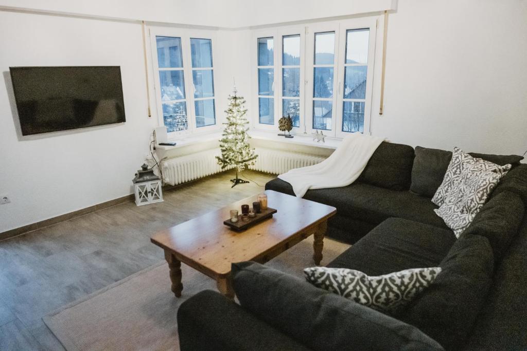 a living room with a couch and a christmas tree at Ferienhaus Schneeweiß in Winterberg