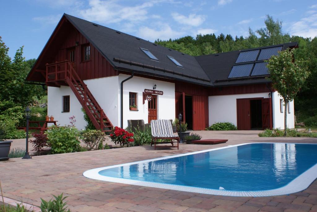 uma casa com uma piscina em frente em Guest House K74 em Jablonné v Podještědí
