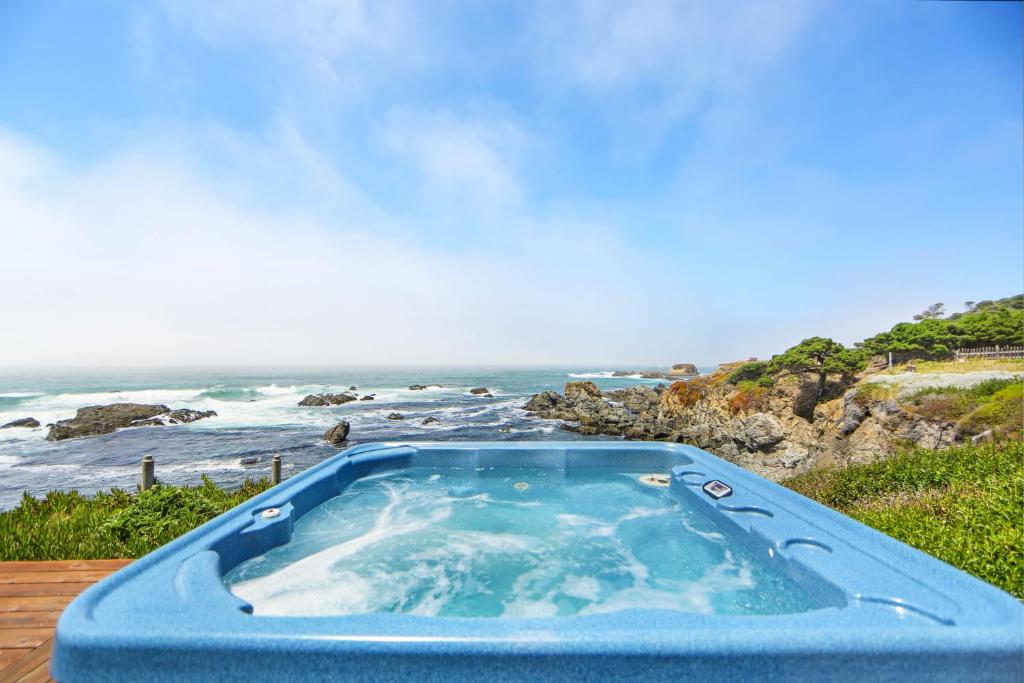 a blue tub sitting on top of a table next to the ocean at Marebello in Fort Bragg