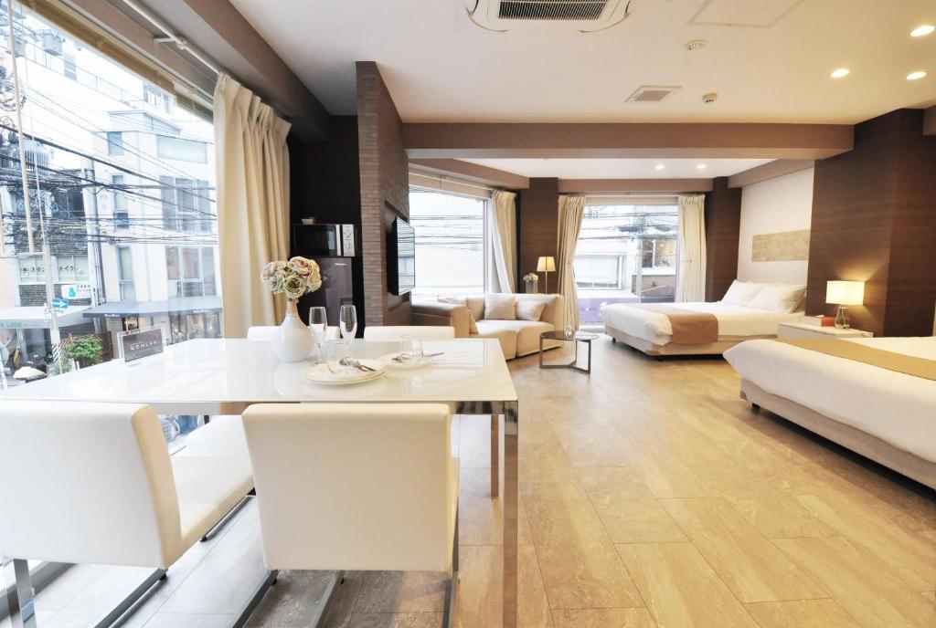 ein Wohnzimmer mit einem Esstisch und einem Sofa in der Unterkunft Senlax Inn Osaka in Osaka