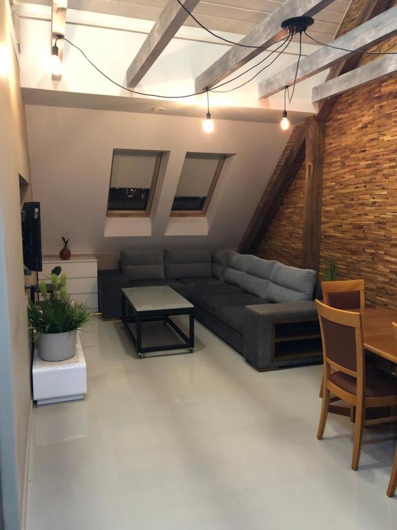 een woonkamer met een bank en een tafel bij Apartament - Loft in Piła