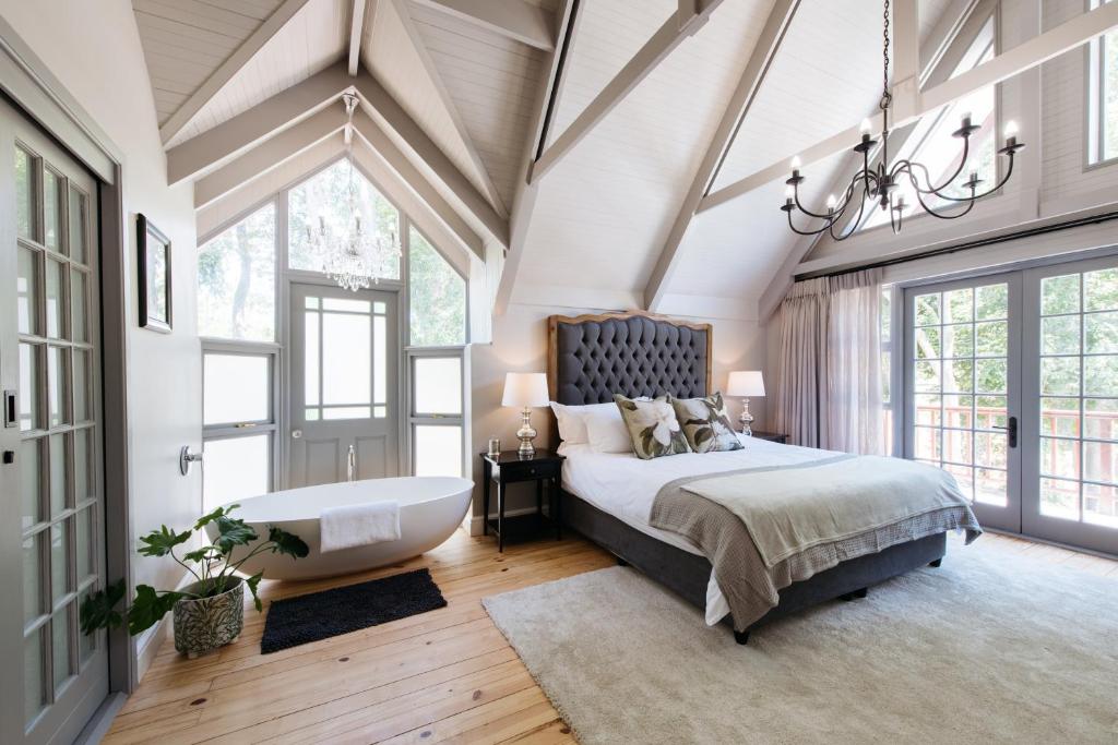Stellenbosch的住宿－Simonzicht Guest House，一间卧室配有一张大床和一个吊灯。