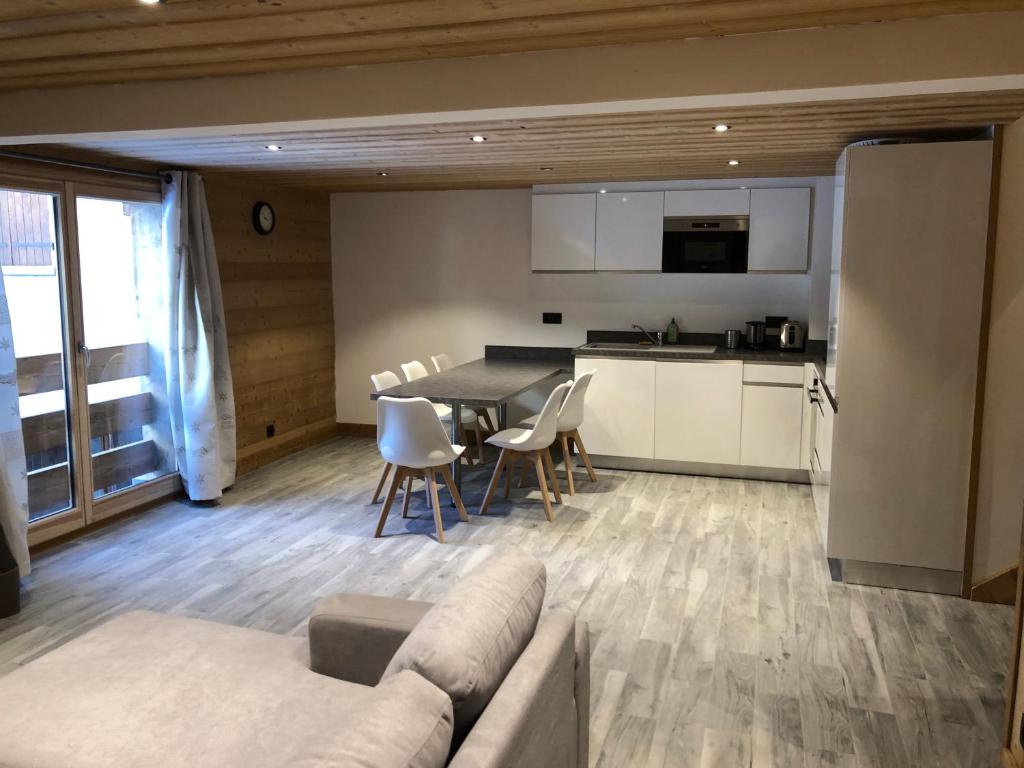 ein Wohnzimmer und eine Küche mit einem Sofa und einem Tisch in der Unterkunft Chalet Victoire in Chamonix-Mont-Blanc