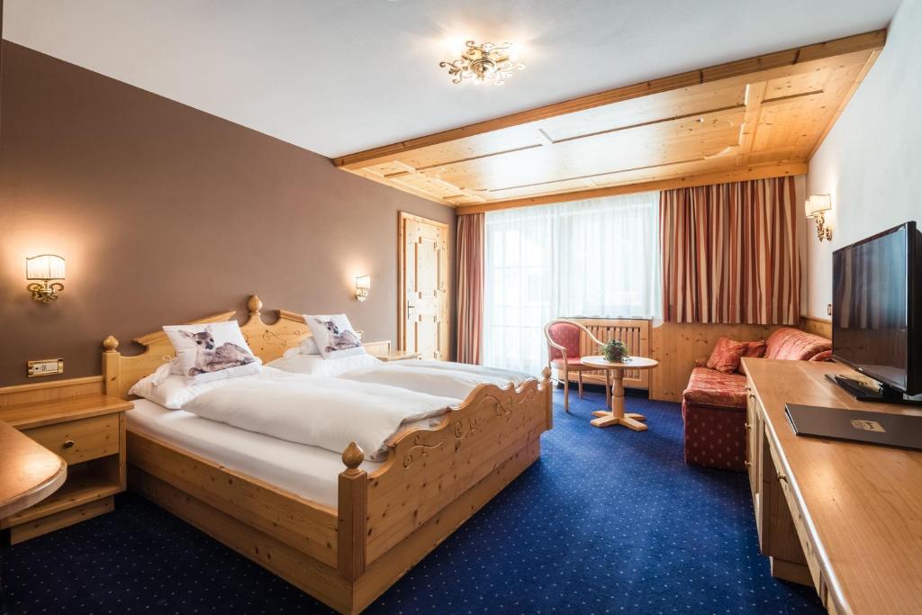 A bed or beds in a room at Alpenhotel Plaza
