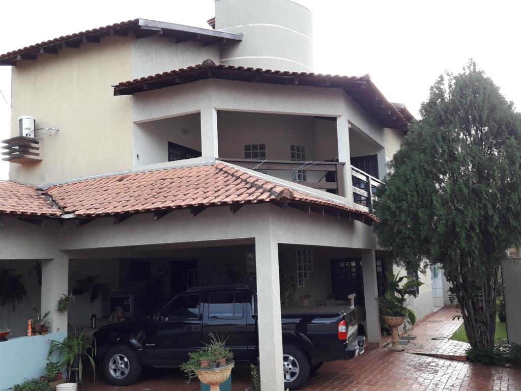 a house with a car parked in front of it at Hostel DS in Campo Grande