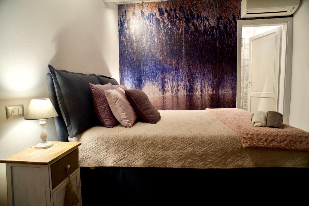 a bedroom with a bed with a purple wall at Giulietta Suite - Brand New flat in Santa Maria Novella in Florence