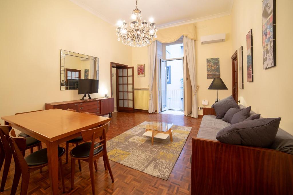 salon ze stołem i kanapą w obiekcie The Dante Apartment By HouseinNaples w mieście Neapol
