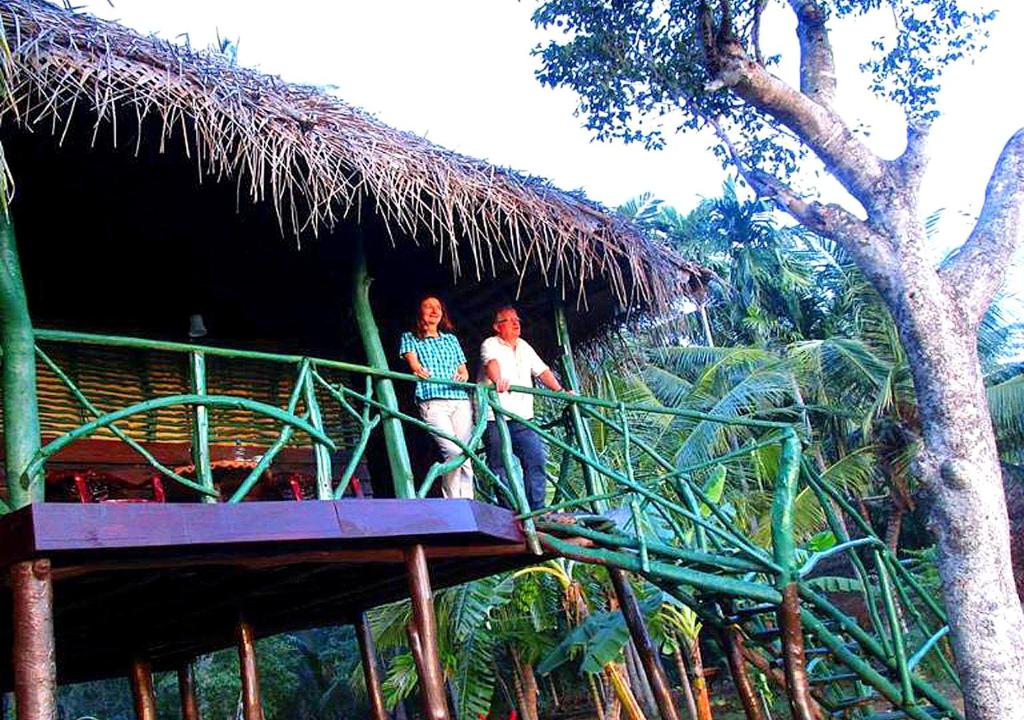 zwei Menschen stehen auf einer Brücke in einer Hütte in der Unterkunft LakeSide Cabana Tissamaharama in Tissamaharama