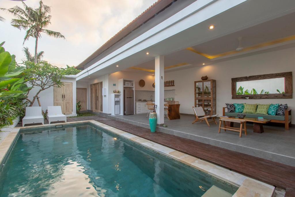 a villa with a swimming pool and a house at Villa Arif in Seminyak