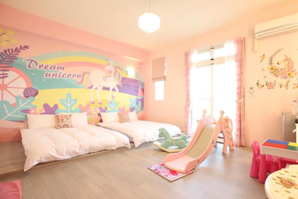 台東市にあるDao Siang Hai B&Bの子供部屋 ベッド2台、ユニコーンの壁画が備わります。