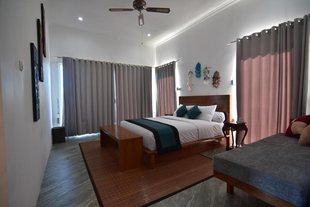 a bedroom with a bed and a couch at Wanagiri Cosmic Nature Villa in Bedugul