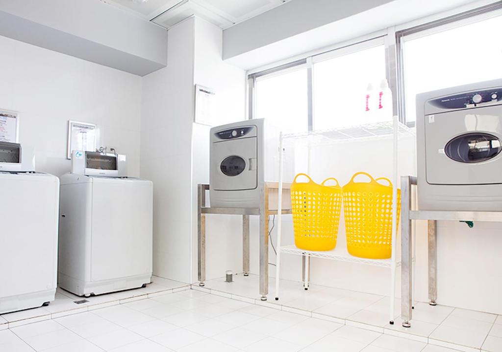 a laundry room with two refrigerators and two machines at Royal Hotel Group- Central Park Branch in Kaohsiung