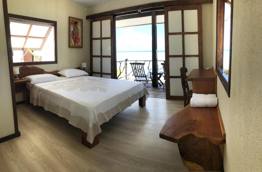 a bedroom with a bed and a view of the ocean at Hakamanu Lodge in Tikehau