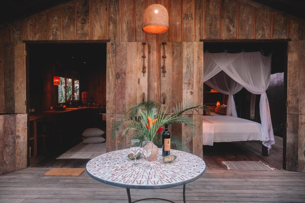 ein Schlafzimmer mit einem Bett und einem Tisch mit einer Flasche Wein in der Unterkunft Casa BEE Trancoso in Trancoso