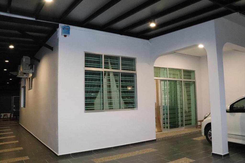a white wall with two windows in a garage at BELLE VILLE in Muar