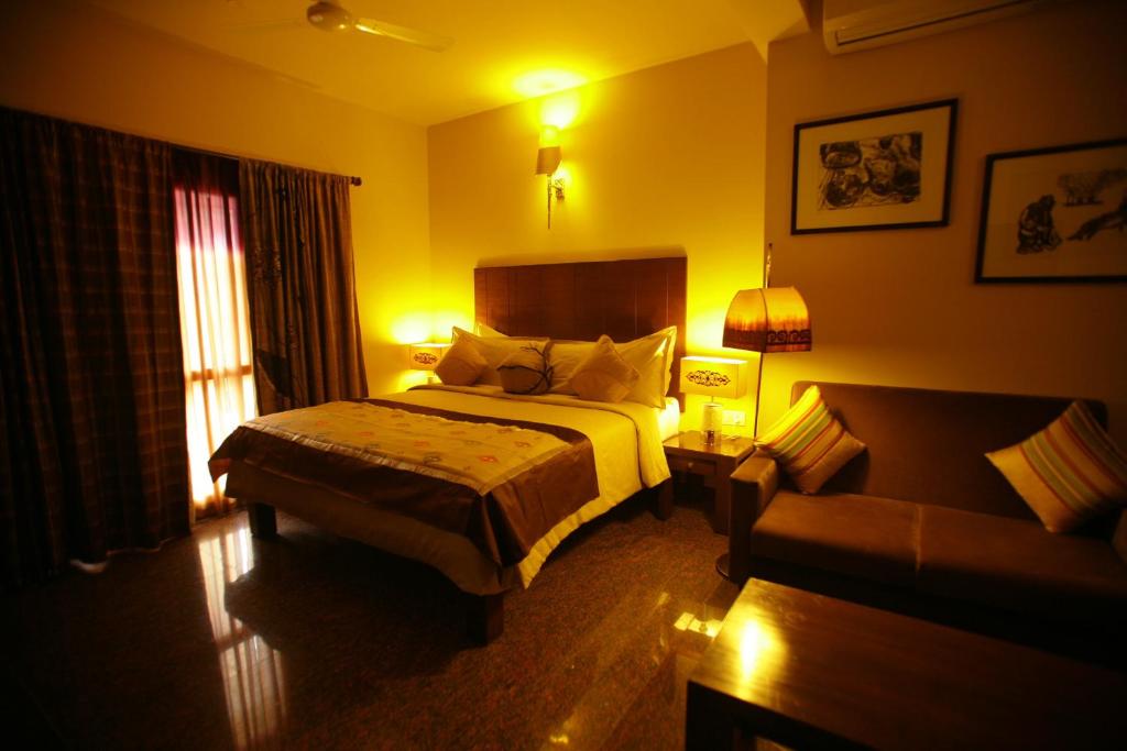 Habitación de hotel con cama y sofá en juSTa Indiranagar, en Bangalore