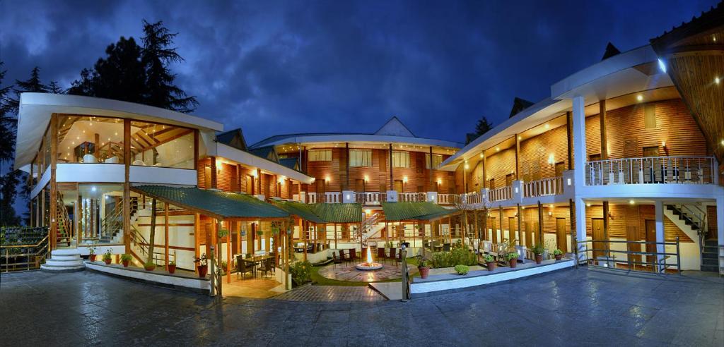 a large building with many windows at night at TreeHouse Chail Villas in Chail