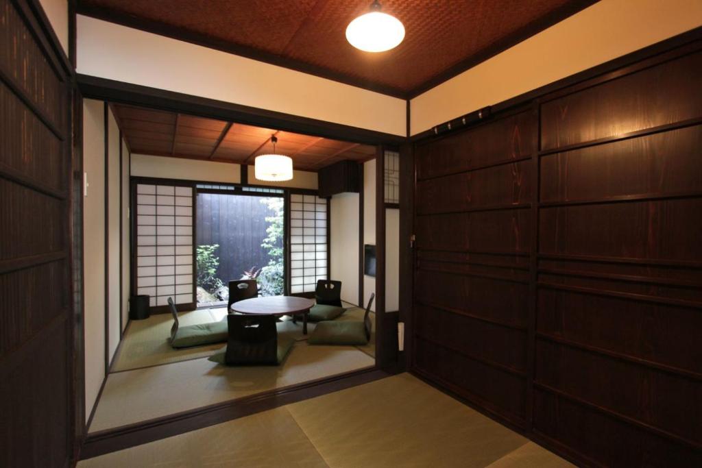 un pasillo con una habitación con una mesa y una ventana en Anzu an Machiya House, en Kioto
