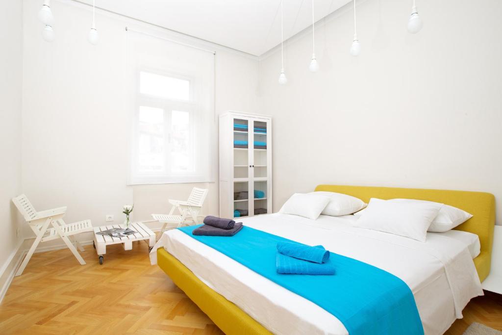 a bedroom with a large bed with a blue blanket on it at Apartment Marmonaut in Split