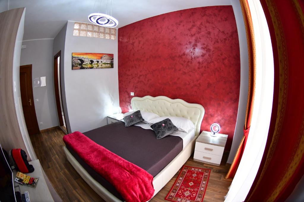 um quarto com uma cama com uma parede vermelha em Royal Termini em Roma