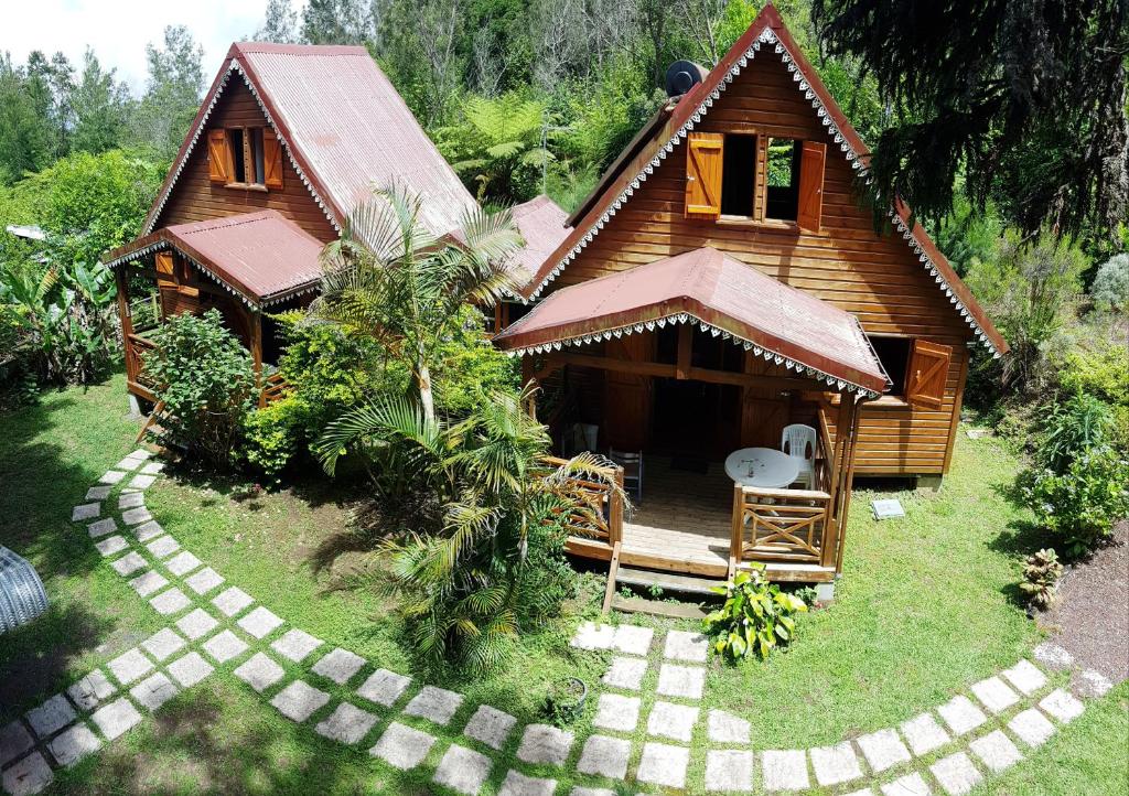 a small wooden house with a pathway leading to it at Chalet des plaines in La Plaine des Palmistes