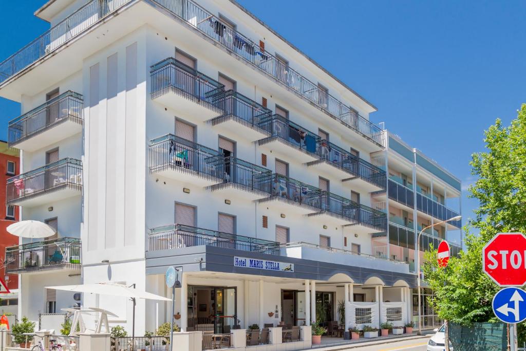 an apartment building with balconies and a stop sign at Hotel Maris Stella in Riccione
