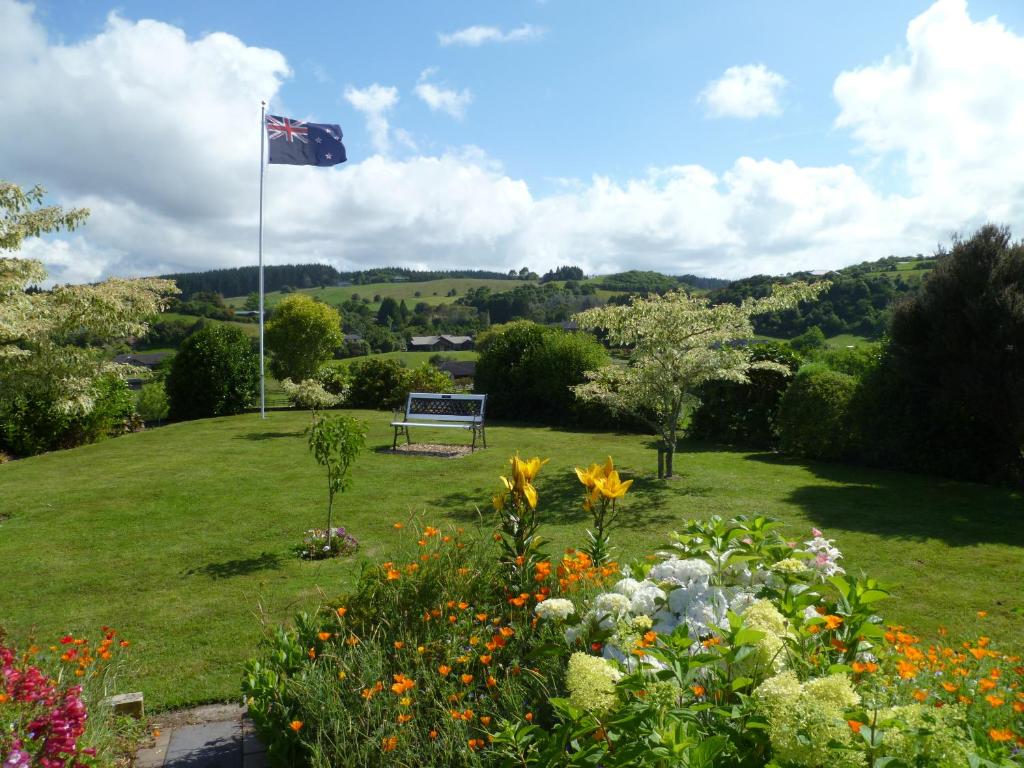 una bandera en un poste en un campo con flores en Bellarosa B&B, en Rotorua