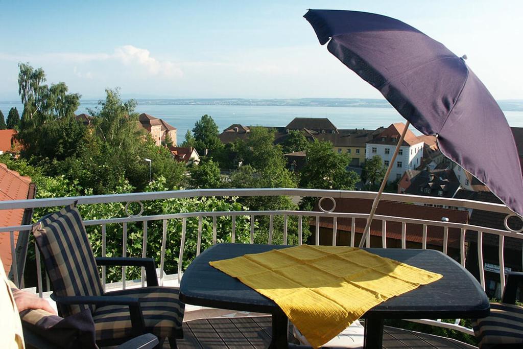 einen Tisch mit Sonnenschirm auf dem Balkon in der Unterkunft Gästehaus Schiff in Meersburg