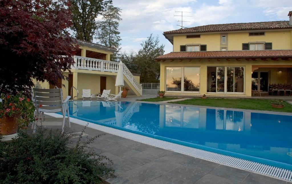 a swimming pool in front of a house at La Casa Sul Fiume in San Daniele del Friuli