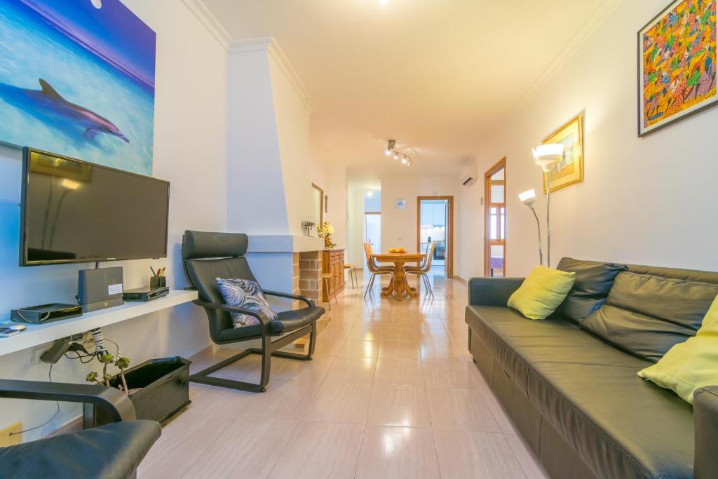 a living room with a couch and a flat screen tv at Can Miquel (Can Picafort) in Can Picafort