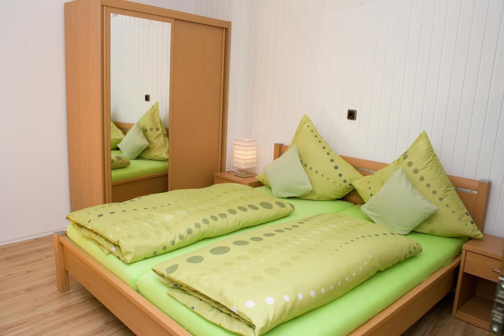 a bedroom with a green bed with a mirror at Ferienhaus Alina in Bernkastel-Kues