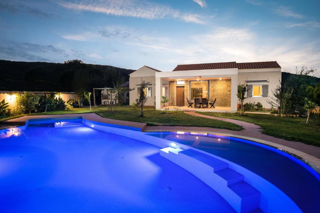 ein großer blauer Pool vor einem Haus in der Unterkunft Three Stars Luxury Villas in Moraḯtika