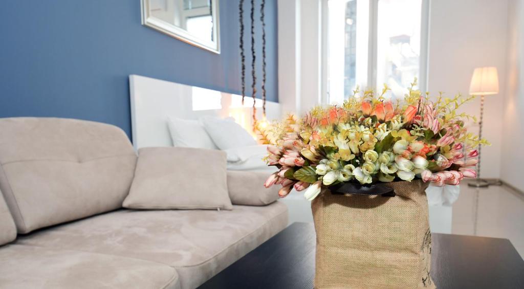 a vase filled with flowers on a table next to a couch at Superior Apartments in Tbilisi City