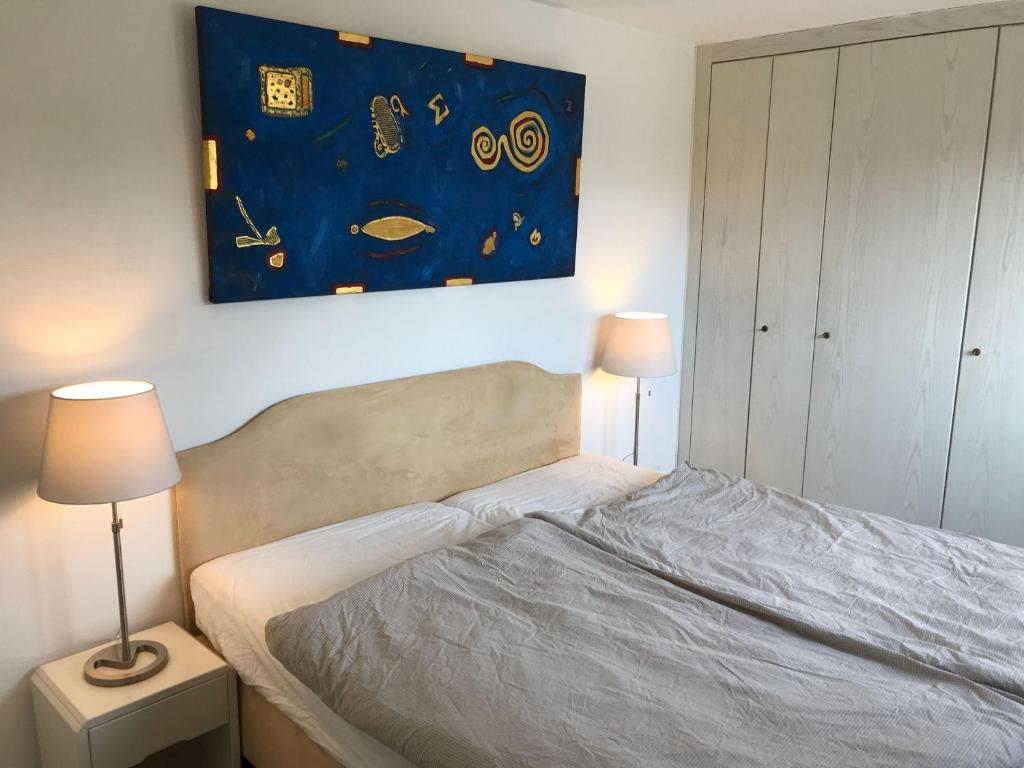 een slaapkamer met een bed met een schilderij aan de muur bij Seebrise-Sylt in Westerland