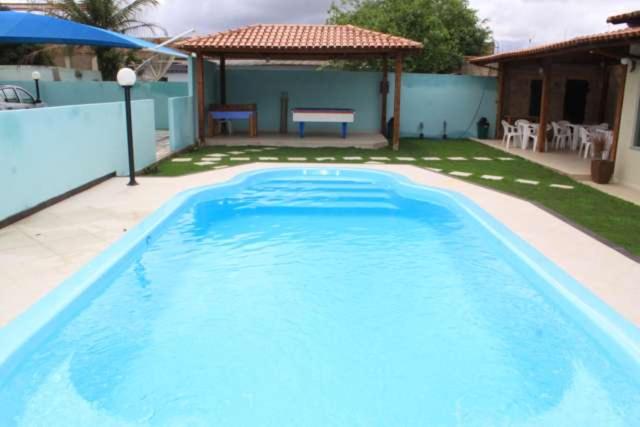 a large blue swimming pool in a yard at Jacarandá Palace Hotel in Teixeira de Freitas