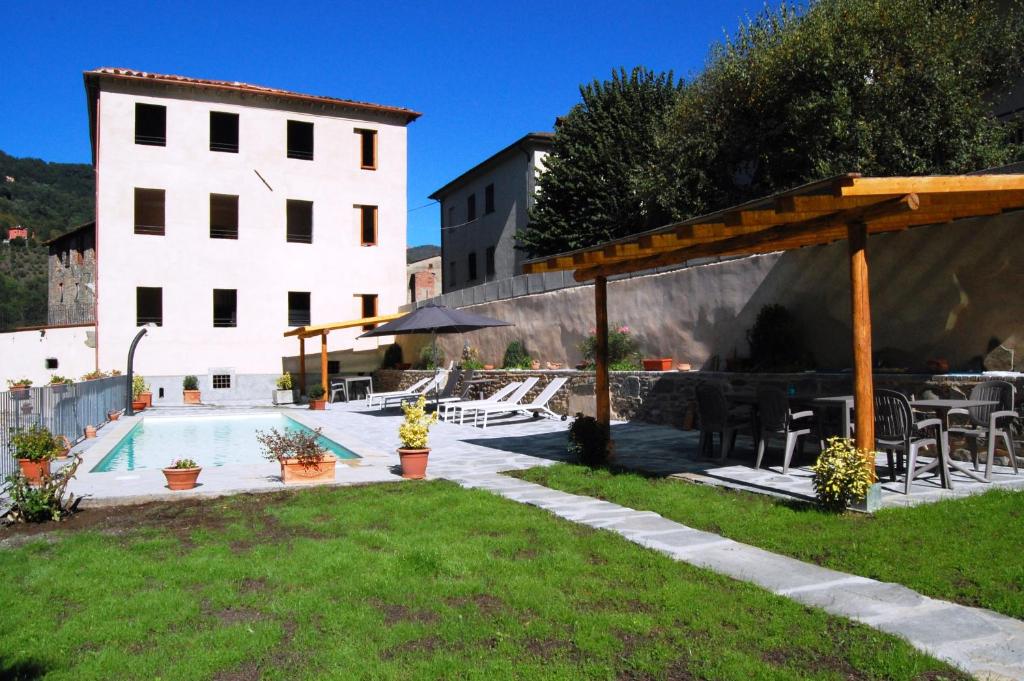 a swimming pool in a yard next to a building at Villa ULQINI in Bagni di Lucca