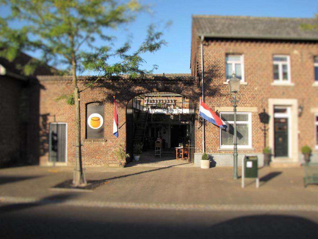 un edificio de ladrillo con banderas delante de él en Koperen keteltje, en Nieuwstadt