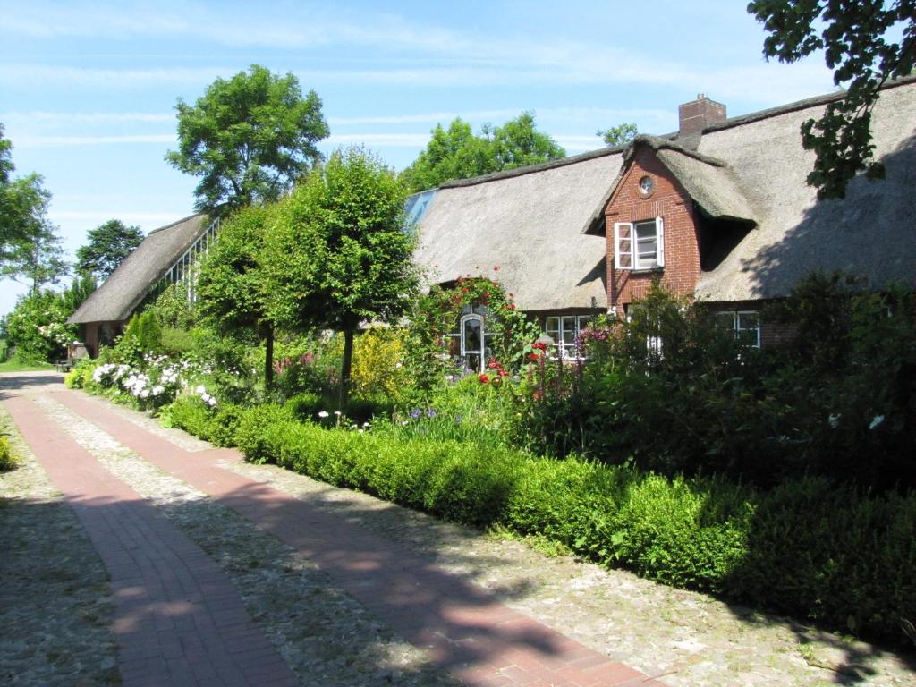 un camino de ladrillo junto a una casa con flores en Nordsee-Paradies, en Barlt
